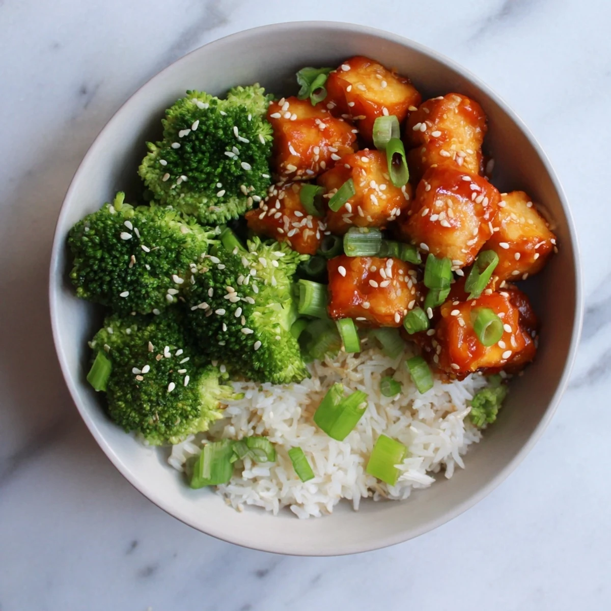 Crispy sticky orange chili tofu bowl with sesame broccoli and fluffy white rice