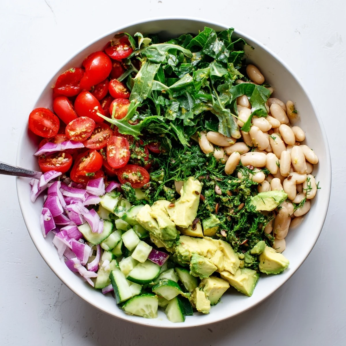 Fresh Mediterranean-inspired salad bowl with white beans avocado greens and bright lemon dressing