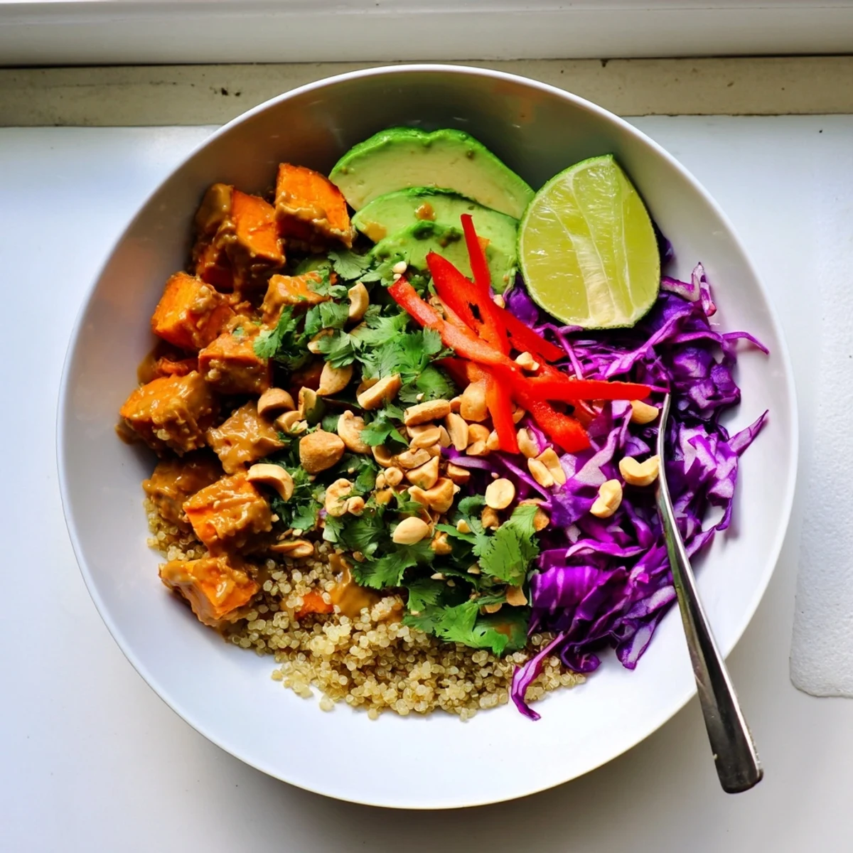 Vibrant nourishing bowl of spicy peanut glazed sweet potatoes served with zesty lime slaw