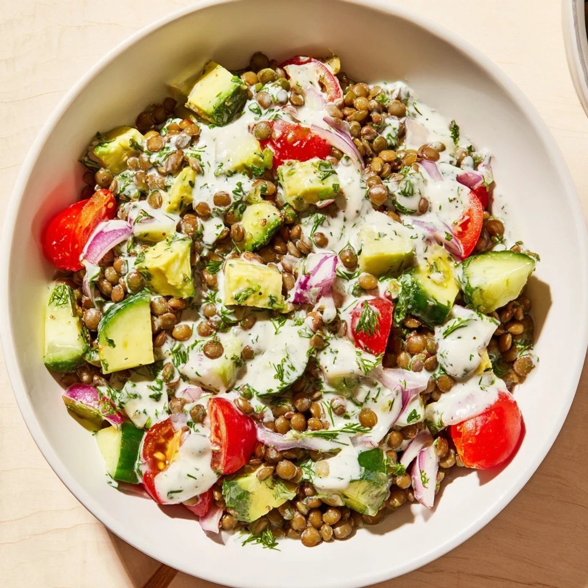 Close-up of vibrant avocado dill lentil salad drizzled with tangy Greek yogurt herb dressing