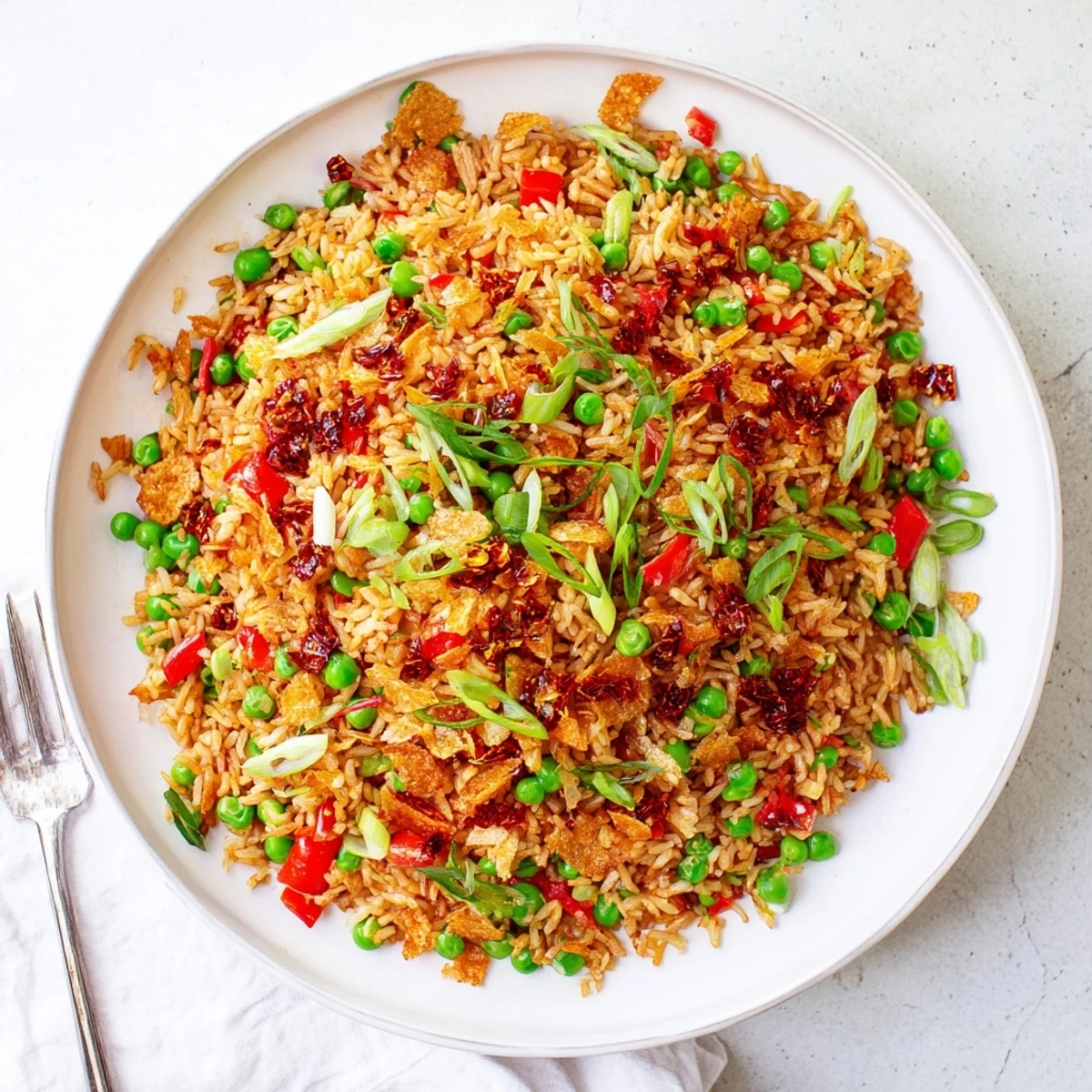 Golden fried rice tossed with spicy chili crisp and crispy garlic chips garnished with fresh green scallions