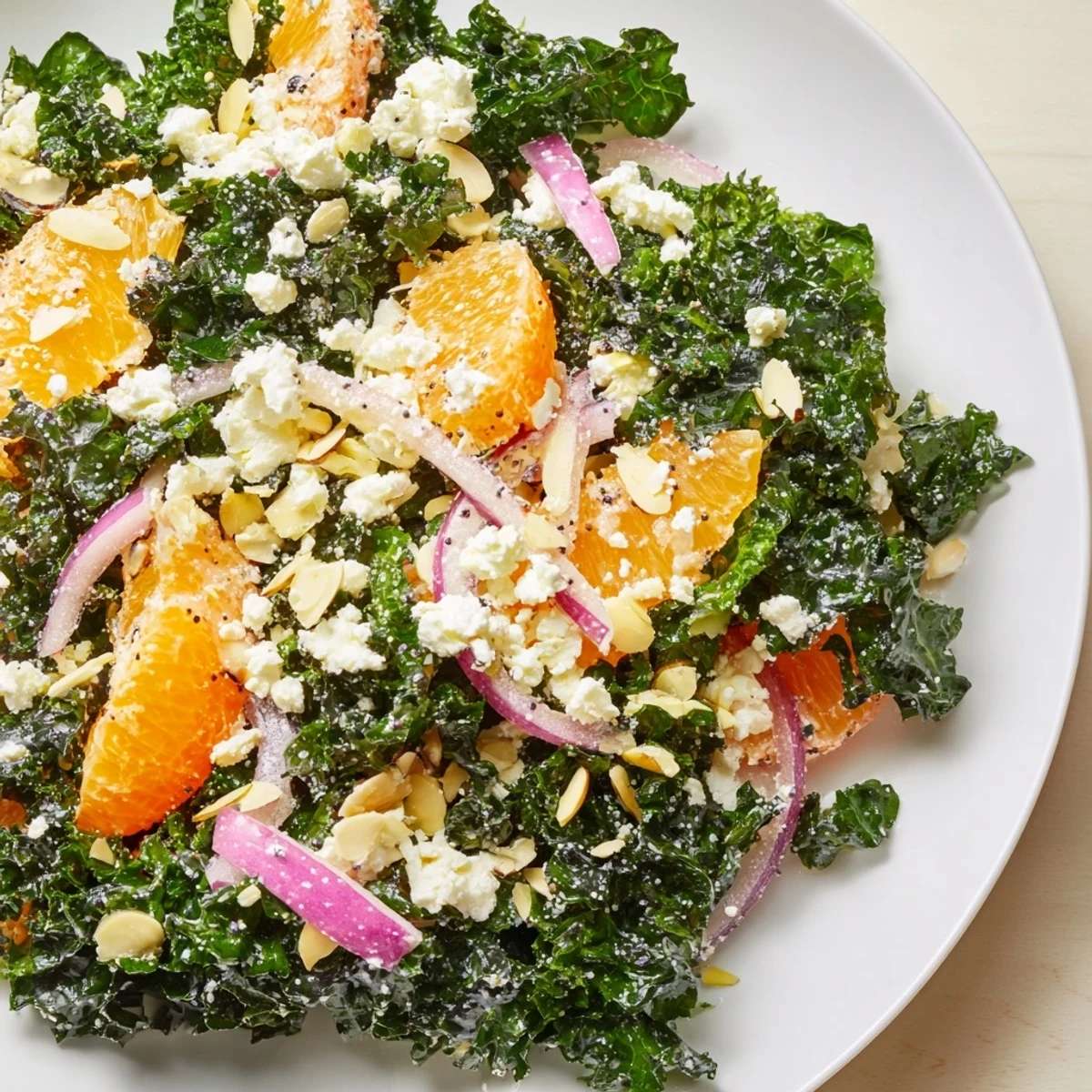 Vibrant kale citrus almond salad topped with toasted nuts and juicy orange segments