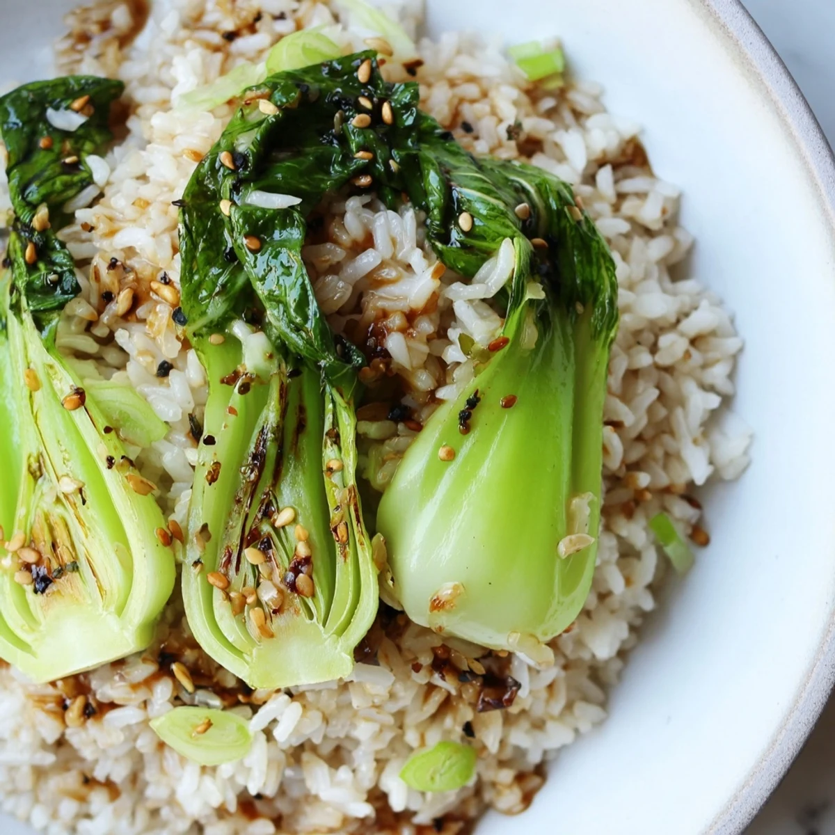 Fluffy garlic ginger jasmine rice steaming in a bowl alongside tender glossy bok choy