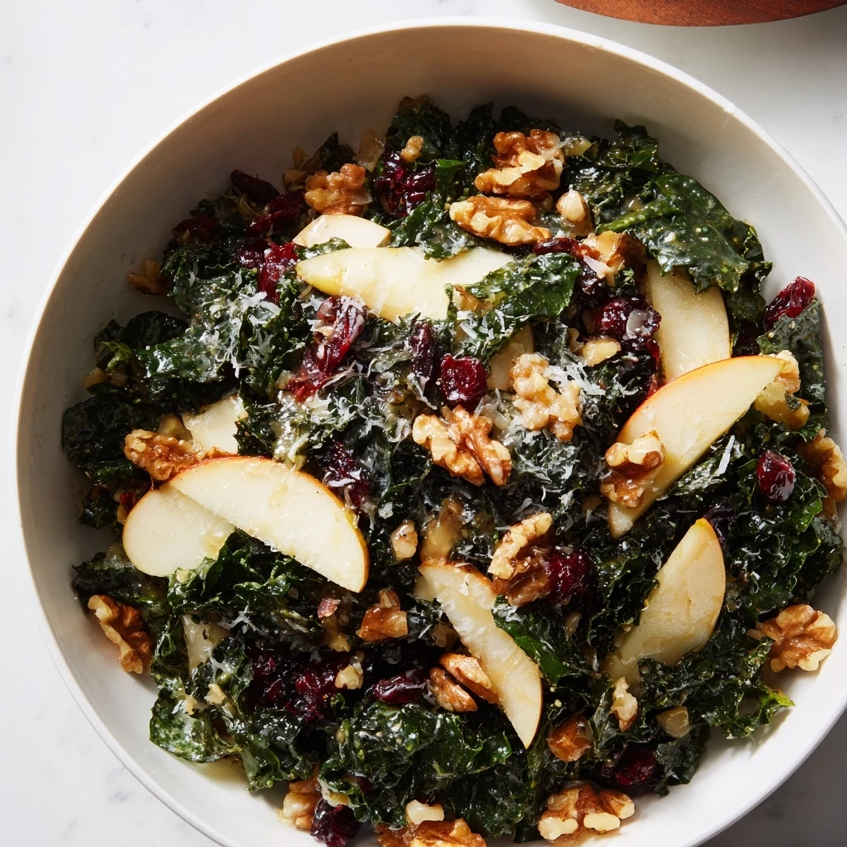 Shaved Kale Apple Walnut Salad in a rustic bowl drizzled with glossy maple dressing