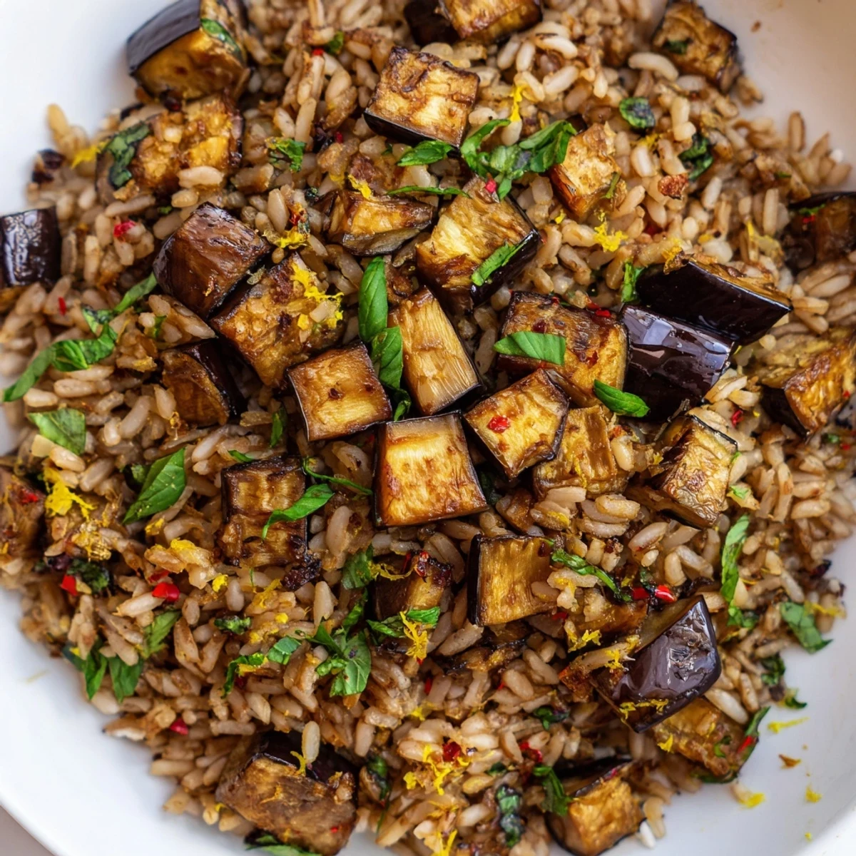 Golden roasted eggplant crowns fluffy garlic herb brown rice garnished with fresh parsley