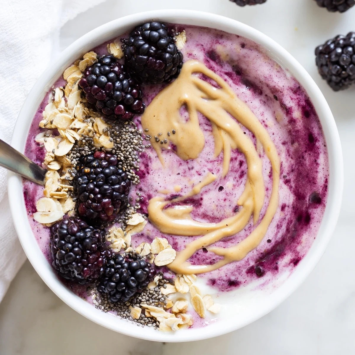 Blackberry Vanilla Oat Smoothie Bowl with Almond Butter Swirl served with fresh blackberries