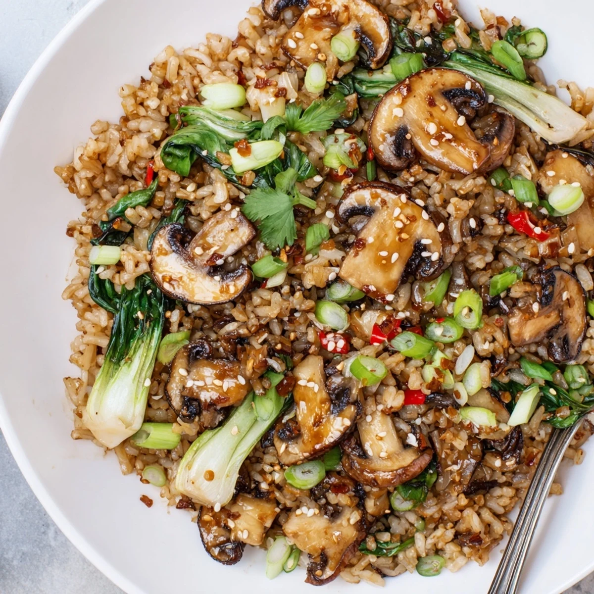 Bowl of Chili Garlic Mushroom Rice with Bok Choy topped with scallions