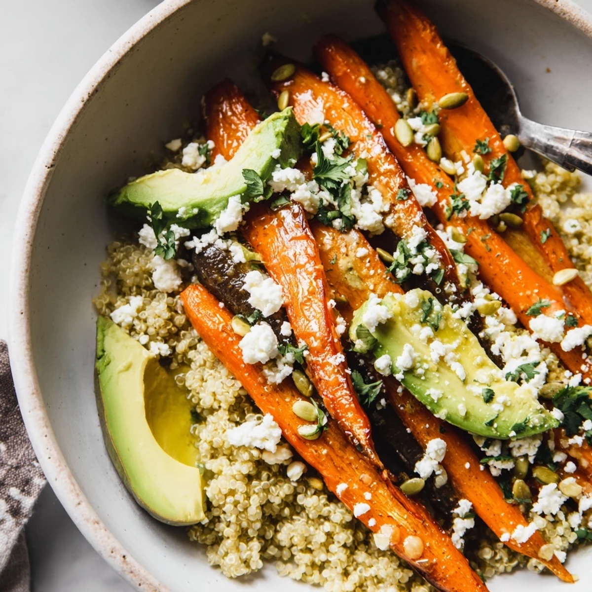 Bright Roasted Rainbow Carrot Quinoa Grain Bowl with Honey Lemon Tahini, sliced avocado