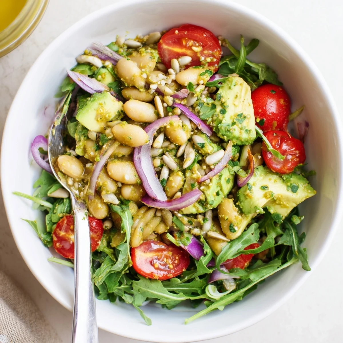 Creamy Avocado Arugula White Bean Salad Bowl with Seeds, lemon tahini glossy dressing.