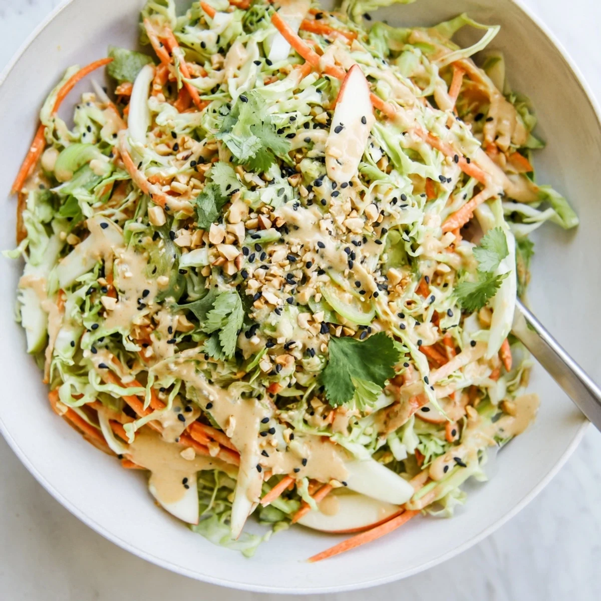 Crisp colorful shreds tossed in Shaved Cabbage Apple Carrot Salad Bowl with Sesame Dressing
