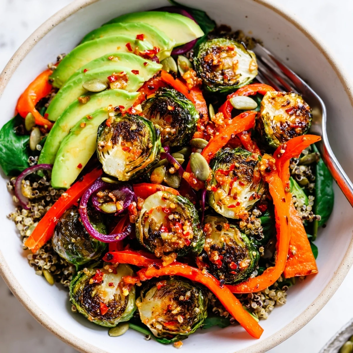Warm Spicy Garlic Roasted Brussels Sprout Veggie Bowl with Chili Flakes over quinoa, lemon