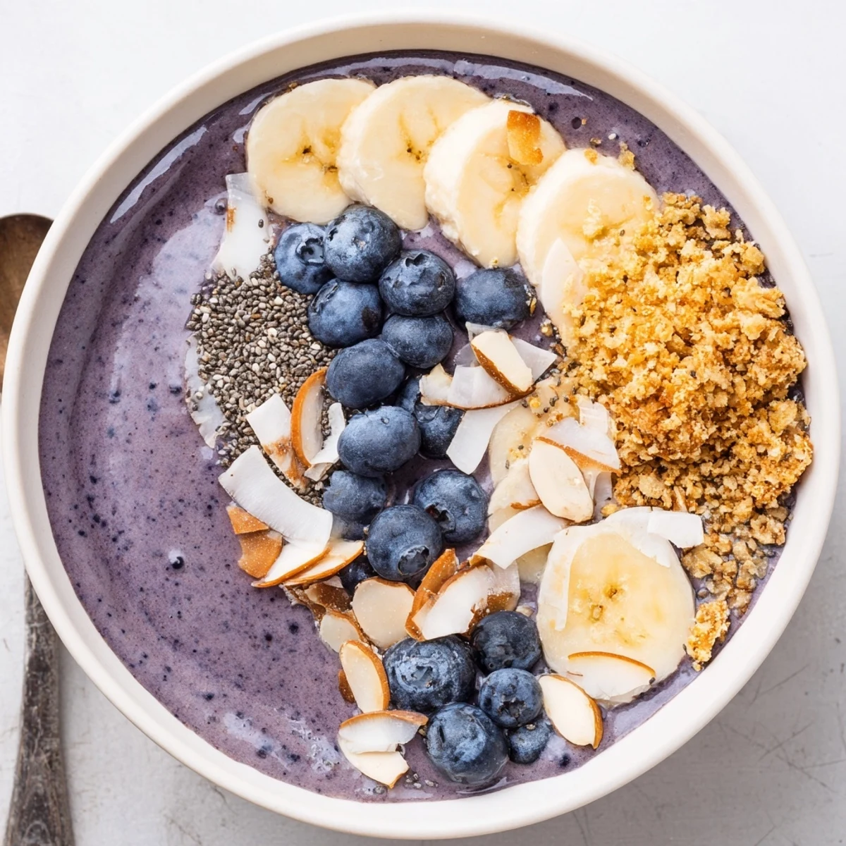 Blueberry Banana Almond Smoothie Bowl with Coconut Crunch topped with toasted coconut