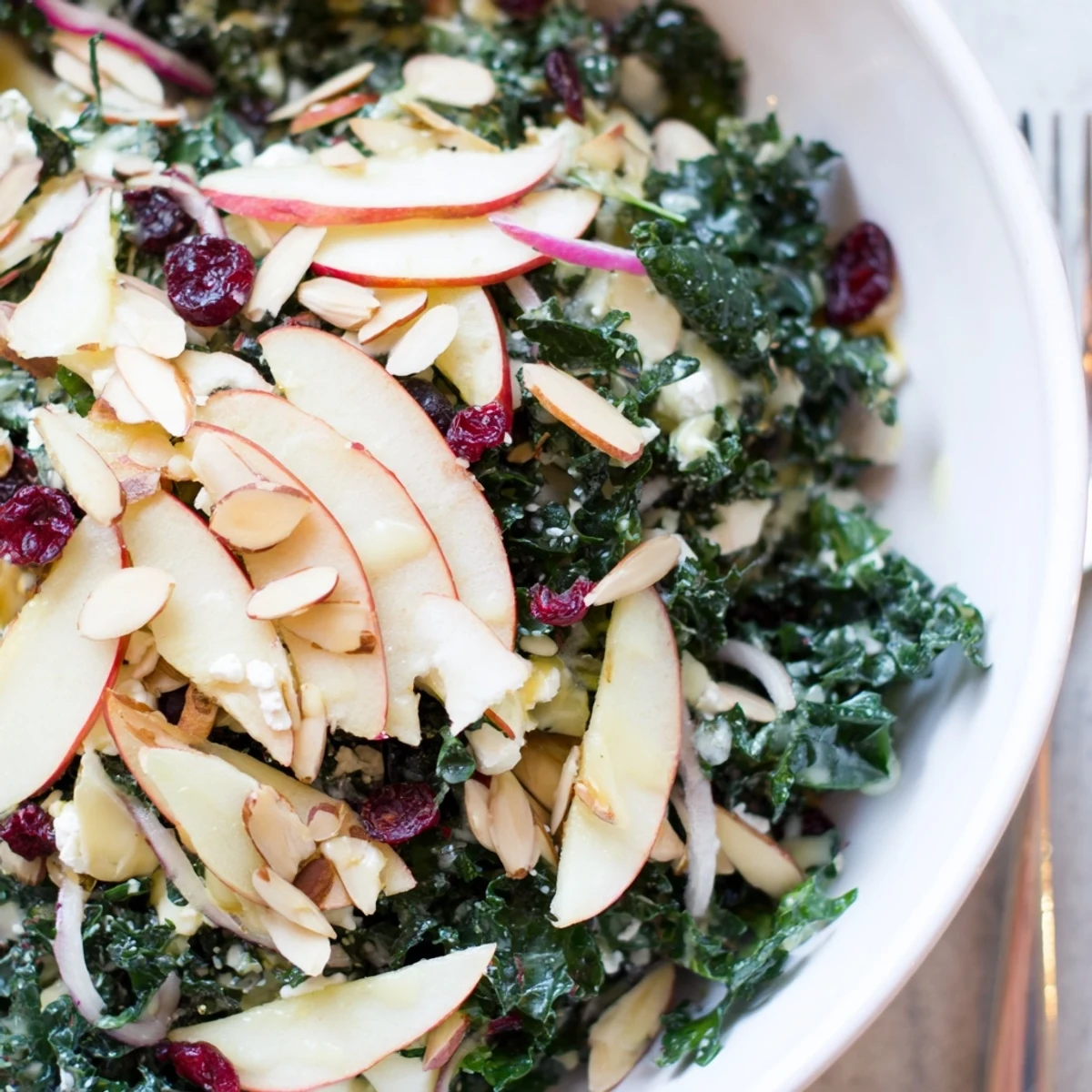 Shaved Kale Apple Almond Salad Bowl with Maple Dressing, crisp apples, toasted almonds.