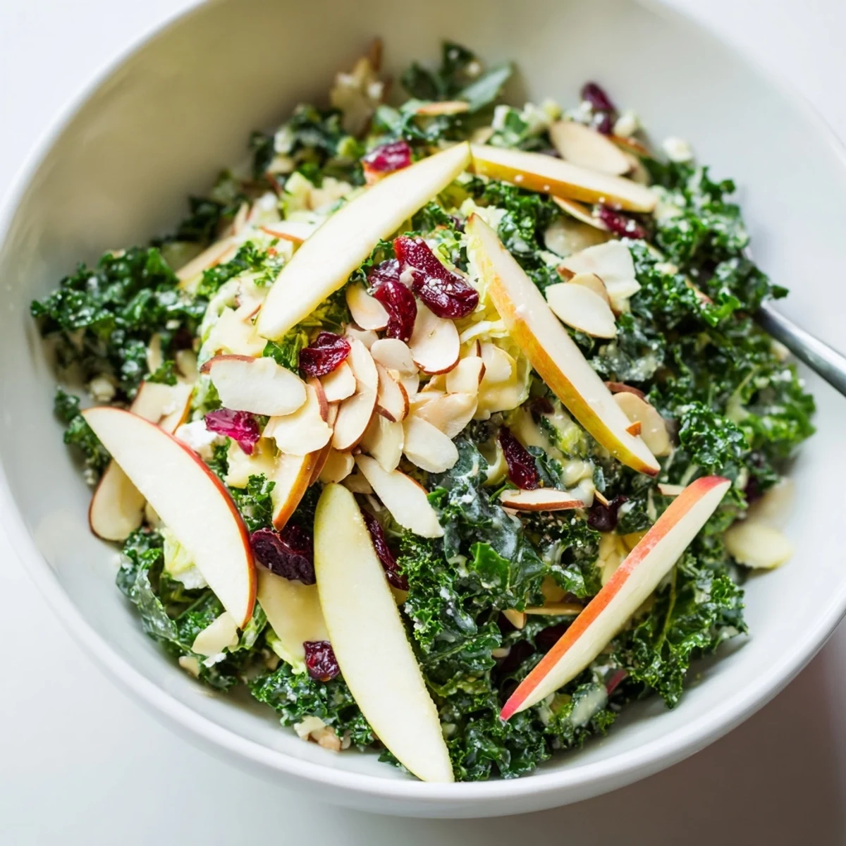 Serve Shaved Kale Apple Almond Salad Bowl with Maple Dressing chilled, tangy and nutty.