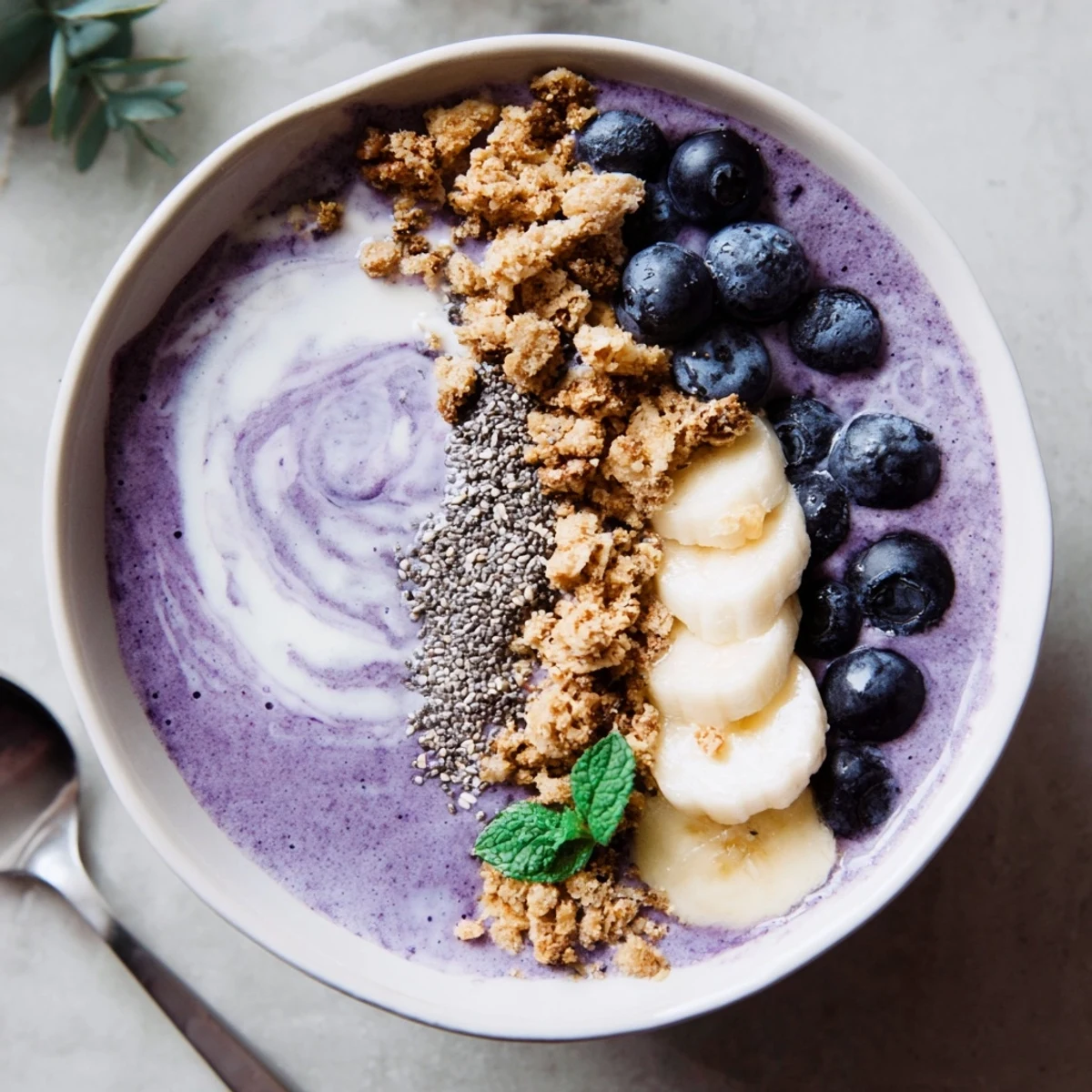 Bright chilled Blueberry Banana Coconut Smoothie Bowl with Granola Clusters, spoon-ready and garnished