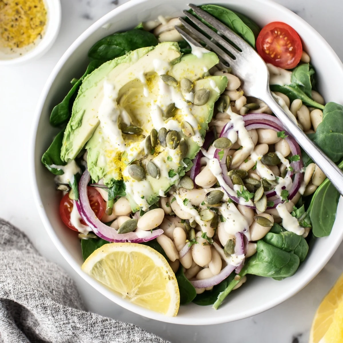 Creamy Avocado Spinach White Bean Salad Bowl with Lemon Zest, juicy tomatoes and parsley