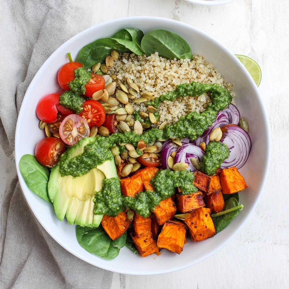 Golden caramelized sweet potatoes layered over fluffy quinoa in a vibrant chimichurri grain bowl with pepitas