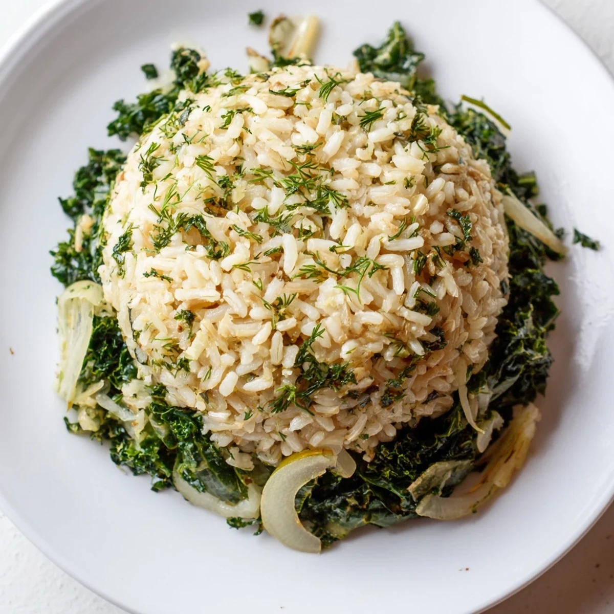 Wholesome plate of lemon herb brown rice paired with sautéed mixed greens and herb garnish