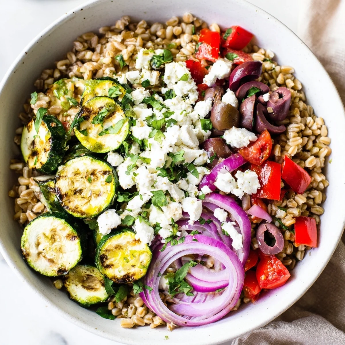 Vibrant farro bowl featuring roasted zucchini crisp veggies and creamy feta in lemon herb dressing