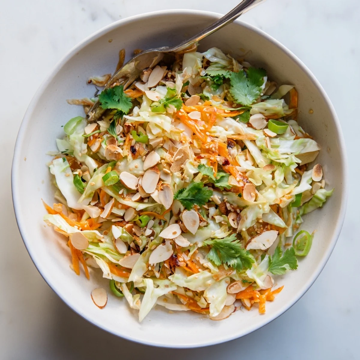 Colorful Asian-inspired salad featuring crisp shredded cabbage carrots and almonds tossed in savory sesame dressing for a refreshing lunch