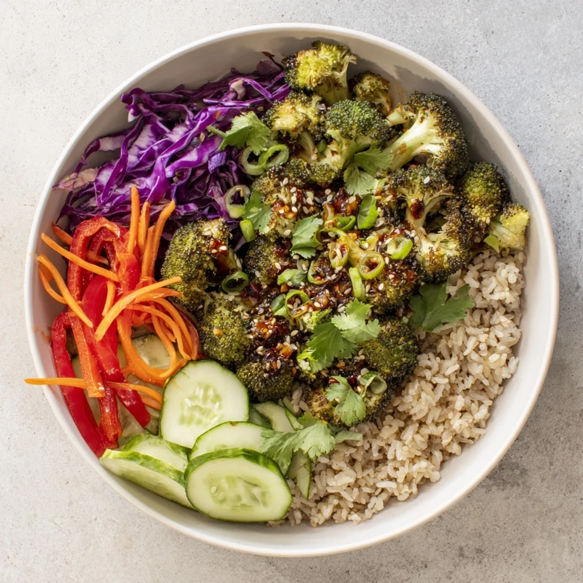 Colorful roasted broccoli bowl with chili crisp garlic glaze over brown rice and fresh vegetables