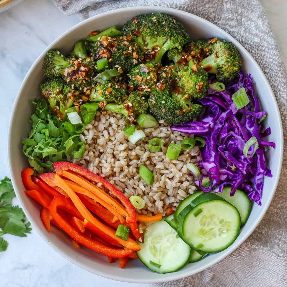 Golden broccoli florets roasted in garlic chili crisp arranged in a nutritious grain bowl with colorful veggies