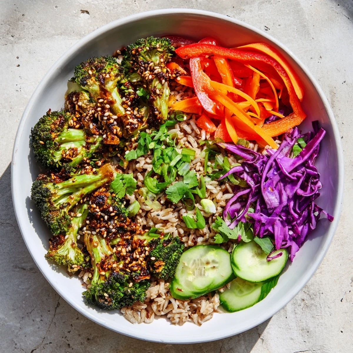 Vibrant veggie bowl featuring spicy chili crisp roasted broccoli served atop fluffy grains with crunchy raw vegetables