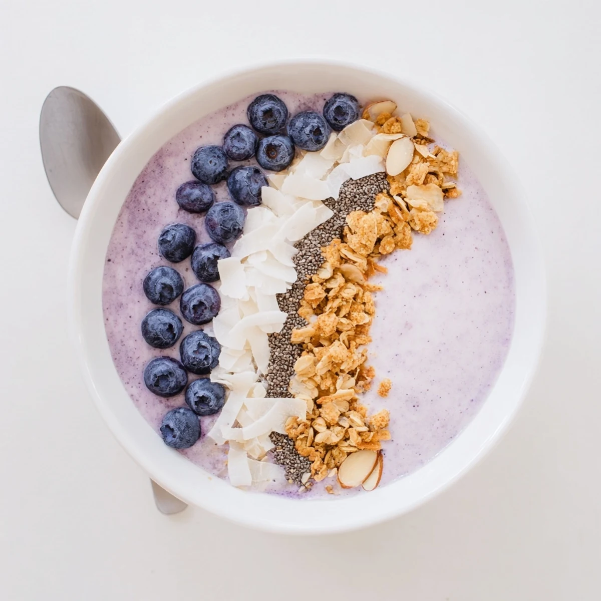 Serve Blueberry Almond Coconut Smoothie Bowl with Granola Clusters garnished with fresh blueberries