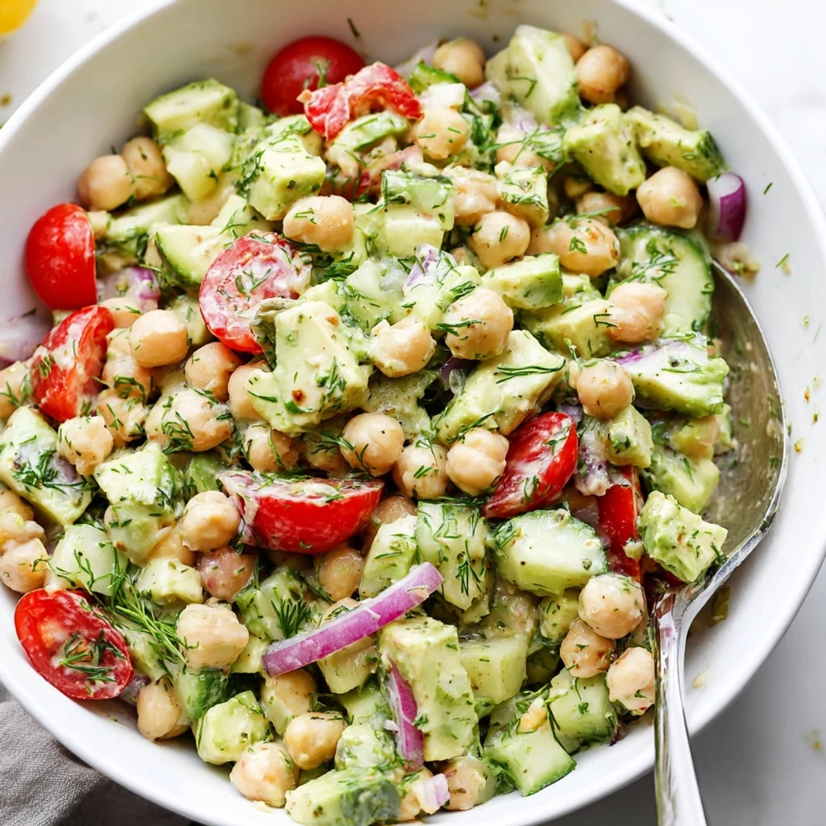 Creamy Avocado Cucumber Chickpea Salad Bowl with Fresh Dill, tangy lemon dressing.