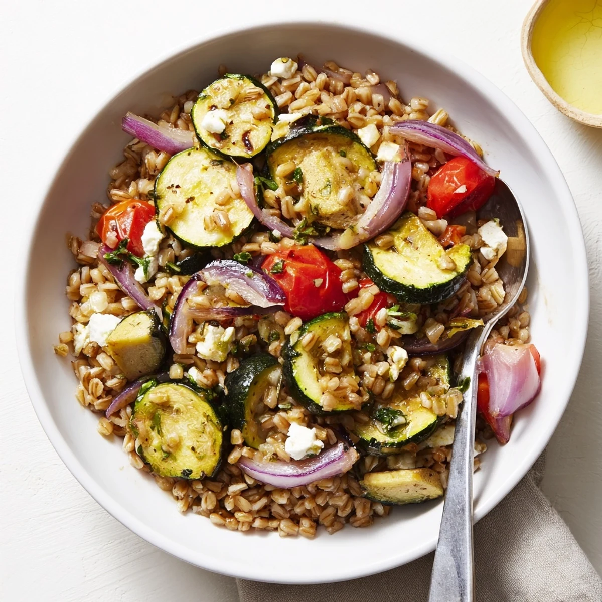 Toasted pine nuts crown Mediterranean Roasted Zucchini Farro Grain Bowl with Feta