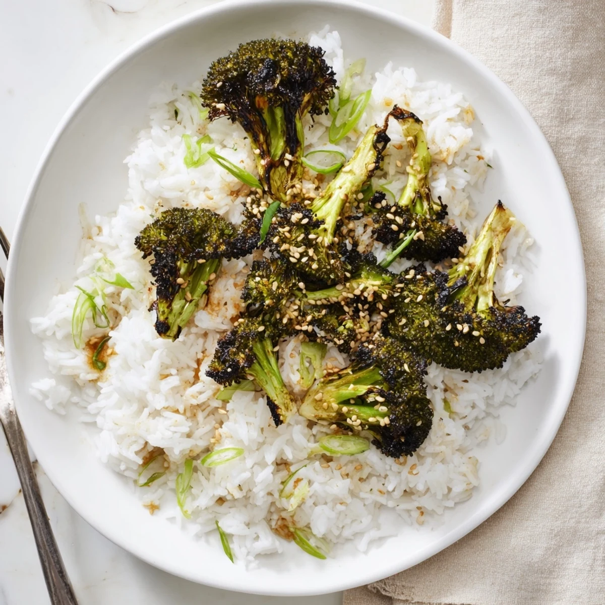 Golden bowl of garlic ginger jasmine rice topped with charred broccoli florets and sesame seeds