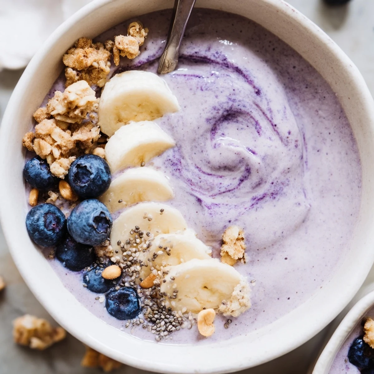 Hearty morning Blueberry Banana Cashew Smoothie Bowl with Granola Clusters, crunchy cashews