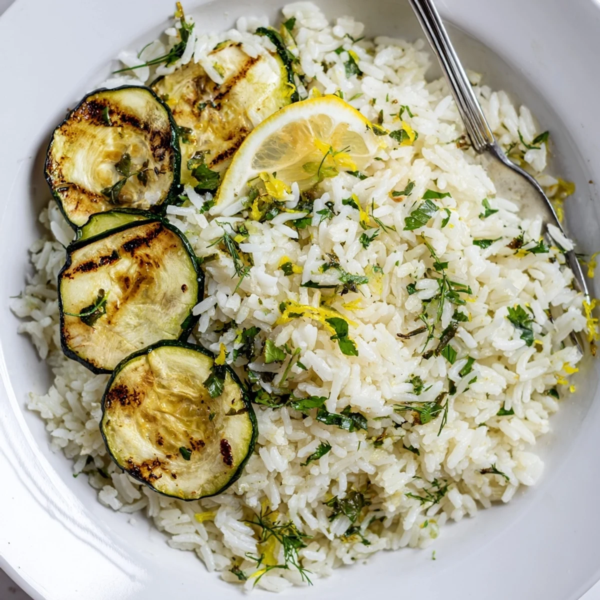 A bowl of Garlic Lemon Herb Jasmine Rice with Charred Zucchini, tender fragrant grains