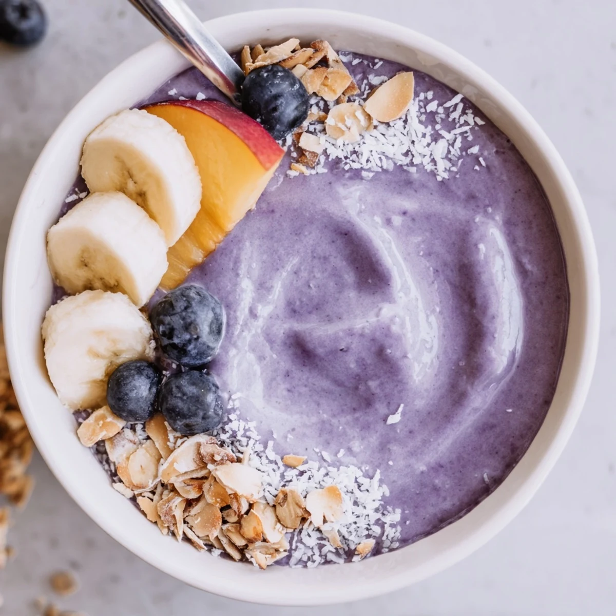 Blueberry Peach Coconut Smoothie Bowl with Almond Crumble, creamy base, toasted almond crunch