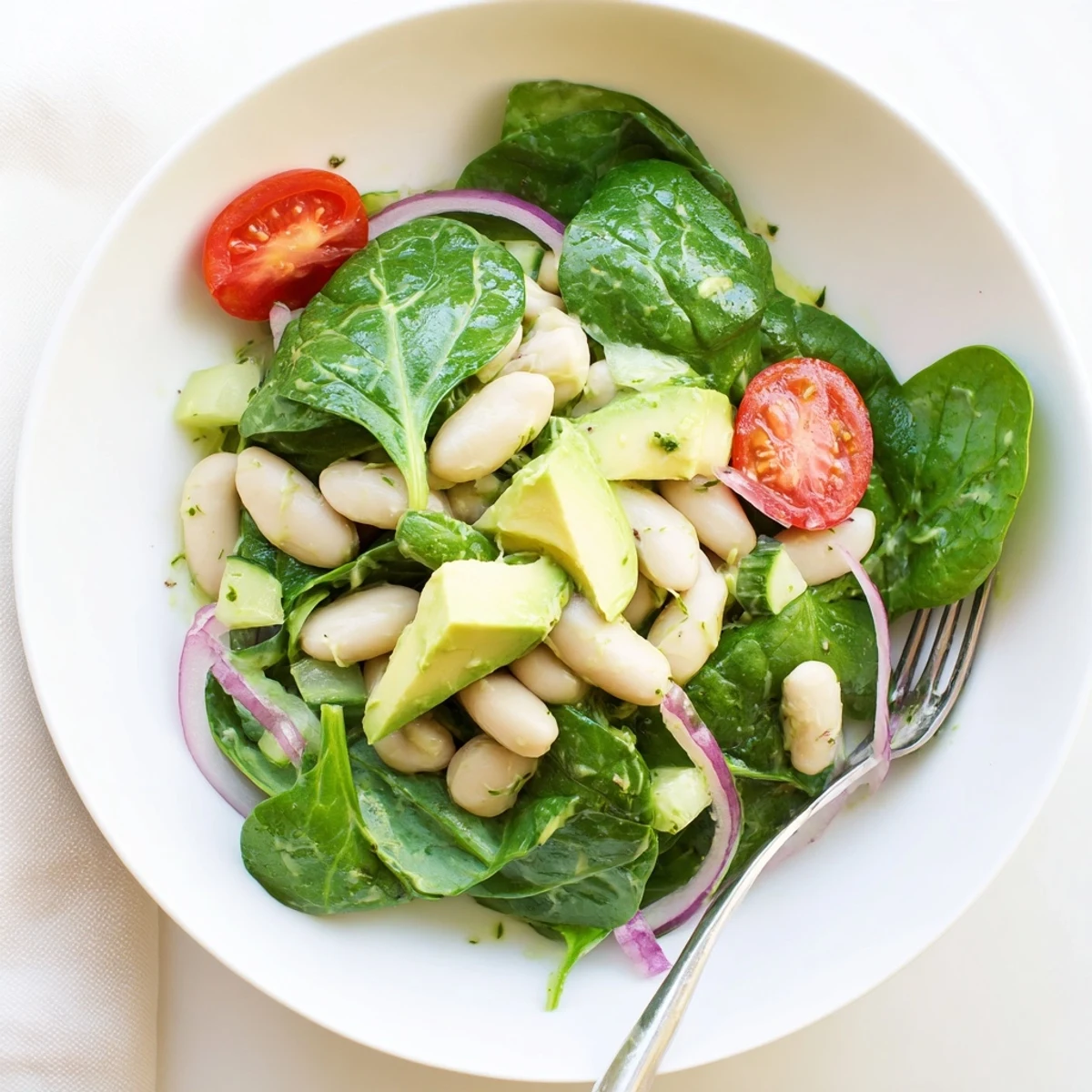 Creamy Avocado White Bean Spinach Salad Bowl with Fresh Herbs, vibrant lemon-garlic dressing glistening