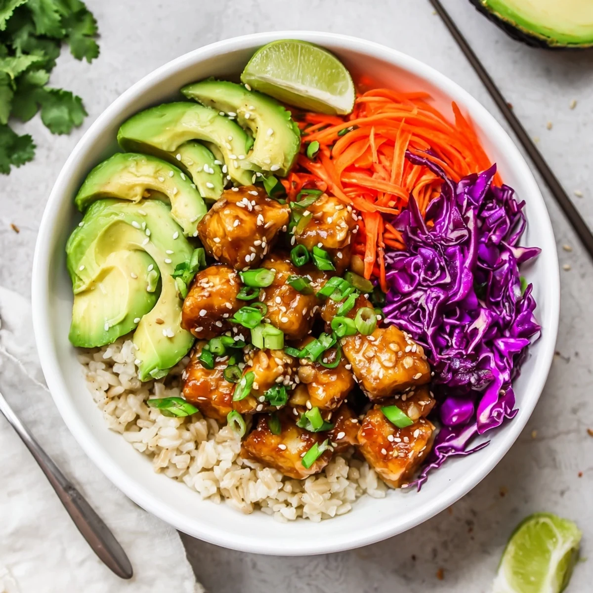 Crispy maple ginger tempeh vegan bowl with sesame cabbage, avocado, and fresh cilantro