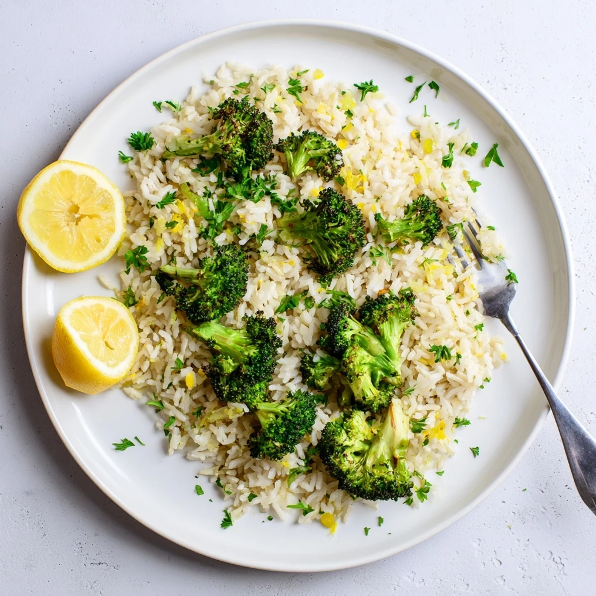 Golden roasted broccoli served over fragrant garlic lemon jasmine rice with wedges