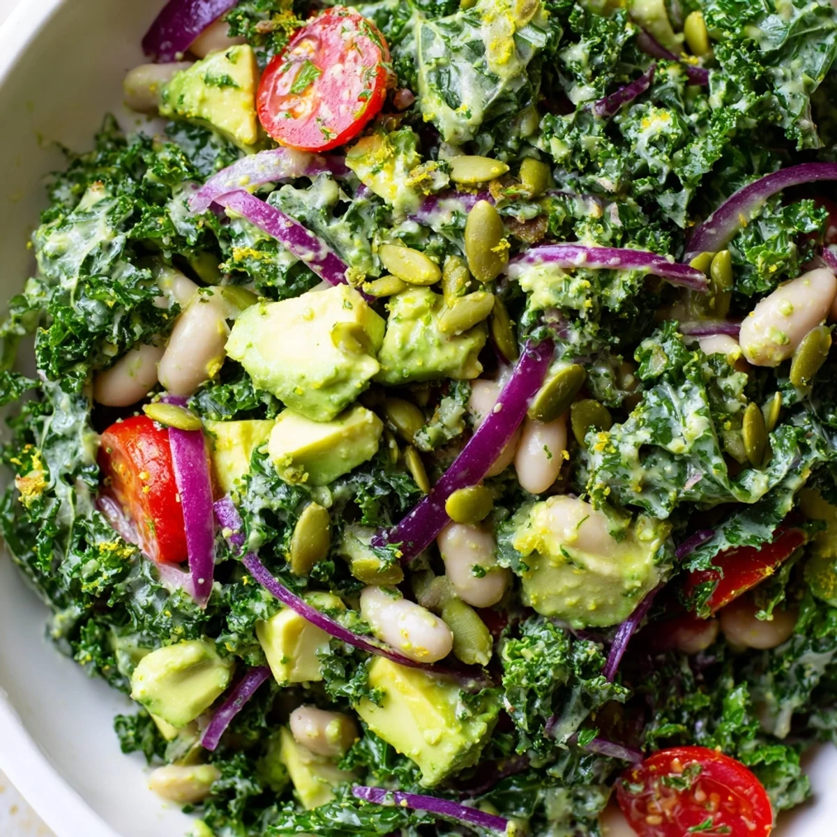 Vibrant kale salad bowl layered with white beans avocado tomatoes and lemon zest