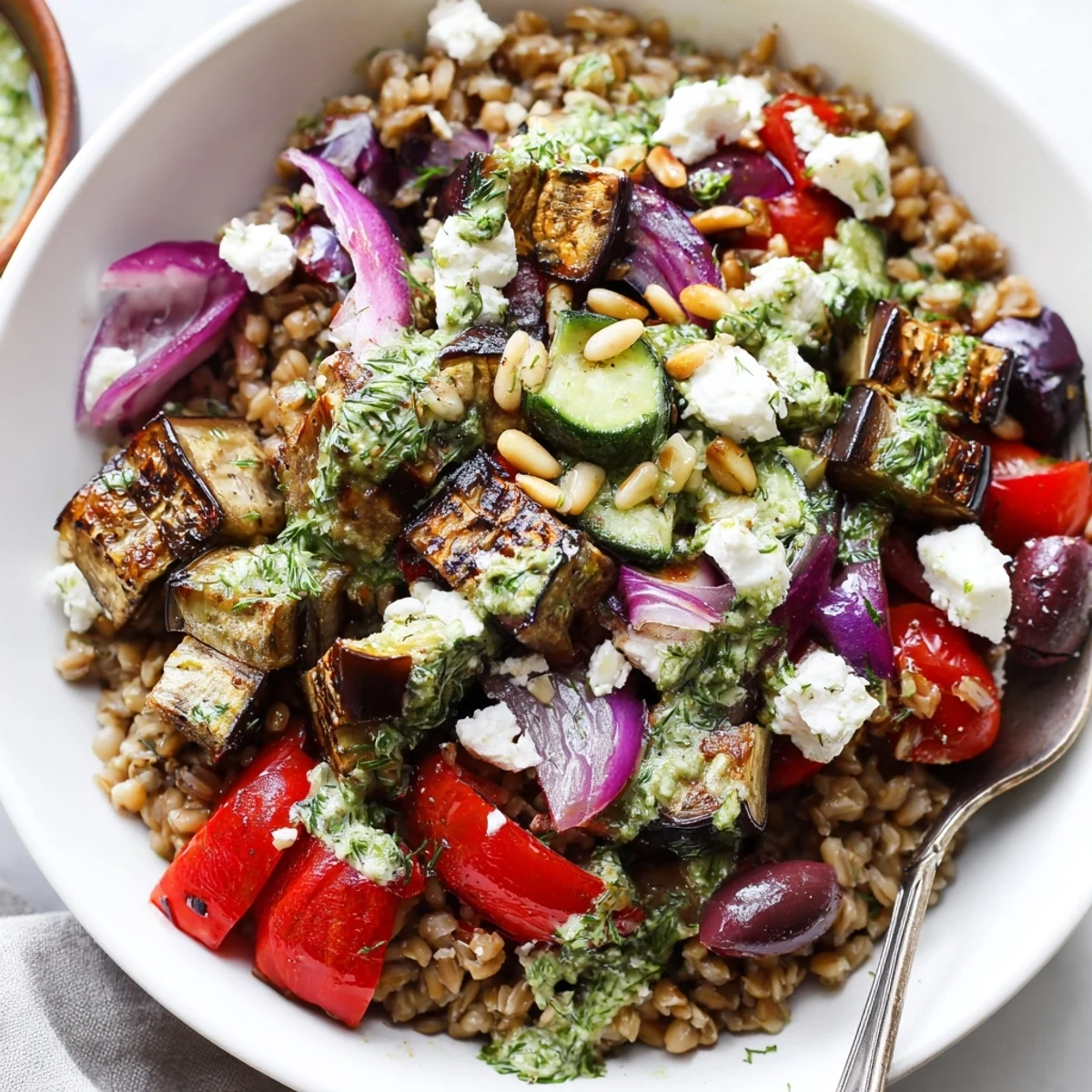 Golden roasted eggplant and nutty farro in a Mediterranean grain bowl with herb yogurt