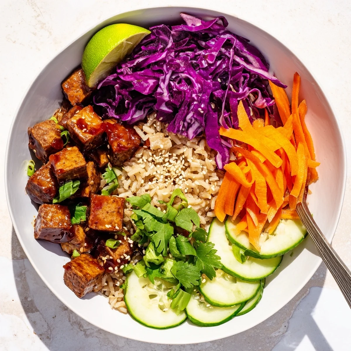 Crispy tempeh coated in sticky maple chili sauce served alongside tangy sesame cabbage and fresh vegetables