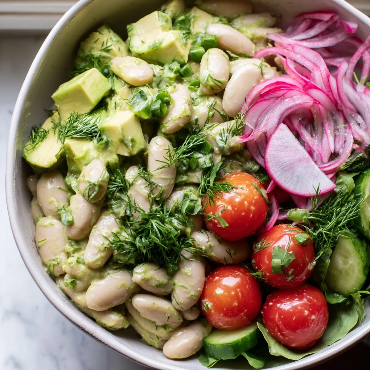 Vibrant white bean salad bowl layered with sliced radishes cucumber and a tangy herb dressing
