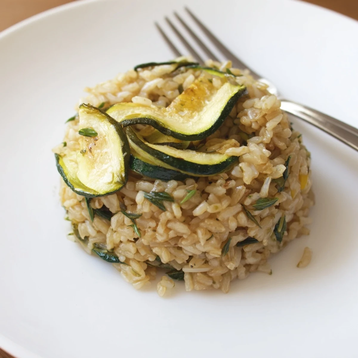 Mediterranean-inspired side dish of garlic lemon herb brown rice mixed with roasted zucchini and chopped parsley for a healthy meal
