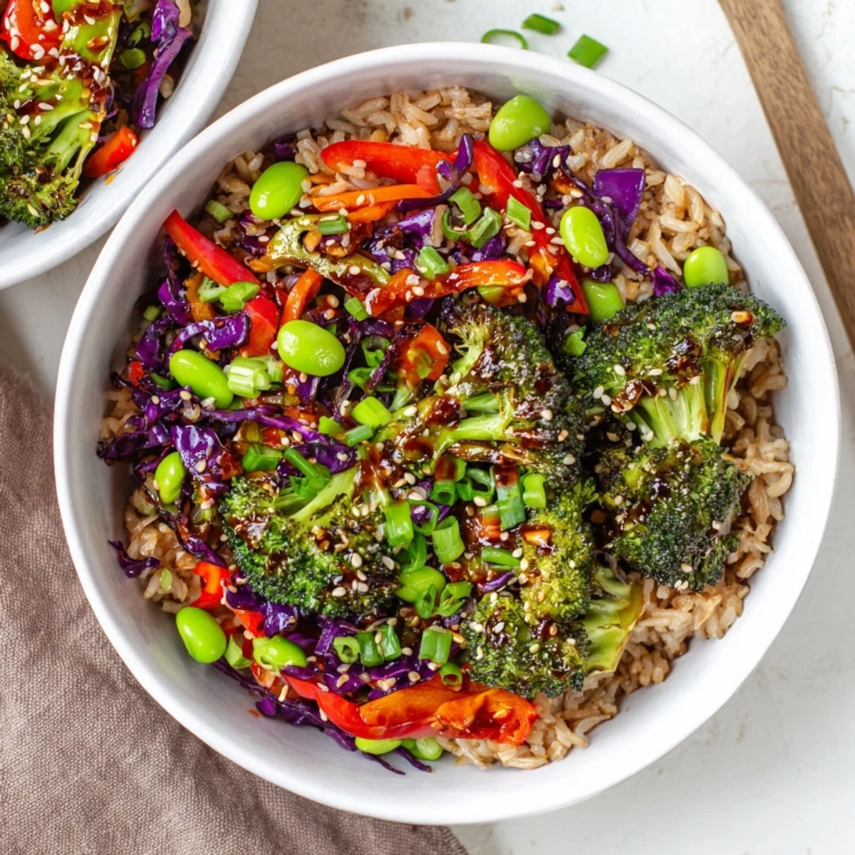 A delicious spicy chili oil roasted broccoli veggie bowl garnished with green onions and sesame seeds.