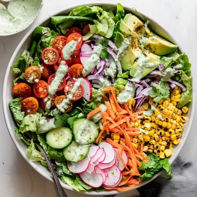 Creamy Avocado Ranch Salad Bowl with Grilled Corn highlights crisp vegetables and diced avocado in a vibrant, colorful serving bowl.