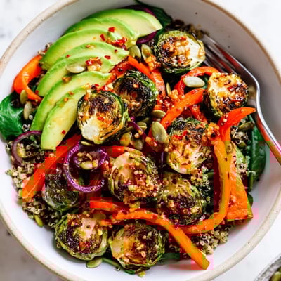 Warm Spicy Garlic Roasted Brussels Sprout Veggie Bowl with Chili Flakes over quinoa, lemon