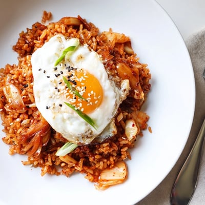 Bowl of Kimchi Garlic Chili Fried Rice with Scallions, sesame-speckled, aromatic