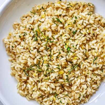 Tender brown rice tossed in zesty lemon herb sauce beside caramelized roasted cauliflower florets